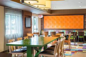 a dining room with a green table and chairs at Fairfield Inn & Suites Lafayette in Lafayette