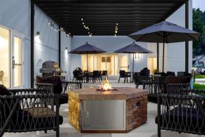 a fire pit on a patio with tables and umbrellas at TownePlace Suites by Marriott Ironton in Ironton