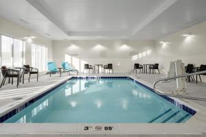 TownePlace Suites by Marriott Ironton في Ironton: مسبح في الفندق مع الكراسي والطاولات