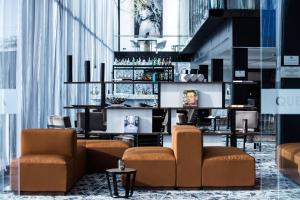 a lobby with chairs and a bar in a building at AC Hotel Queretaro Antea in Querétaro