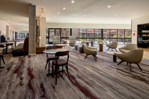 eine Lobby mit Sofas, Tischen und Stühlen in der Unterkunft Courtyard by Marriott Oxnard/Ventura in Oxnard