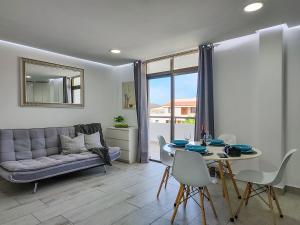 Una sala de estar con un sofá y una mesa con sillas. en Luxury Summerland Los Cristianos AC, en Los Cristianos