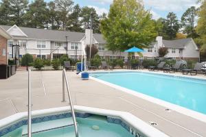 una piscina con sillas y un edificio en Residence Inn Pinehurst Southern Pines, en Southern Pines