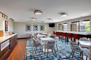 um restaurante com mesas e cadeiras e um bar em Sheraton Milwaukee Brookfield em Brookfield