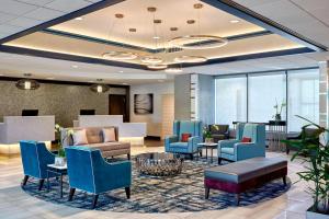 a lobby with blue chairs and a waiting room at Sheraton Milwaukee Brookfield in Brookfield