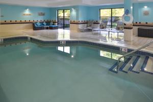Una piscina en un hotel con paredes azules y agua. en SpringHill Suites Pittsburgh Mills, en Tarentum