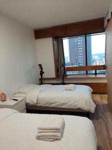 a room with two beds and a window with a city at Paris beaugrenelle: charmante résidence in Paris
