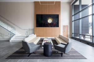 a living room with a couch and two chairs and a table at AC Hotel by Marriott Louisville Downtown in Louisville