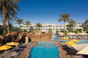 a resort swimming pool with chairs and umbrellas at Marriott's Canyon Villas in Phoenix