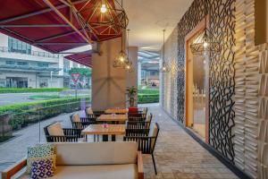 un restaurant avec des tables, des chaises et un mur dans l'établissement Residence Inn by Marriott San Jose Escazu, à San José