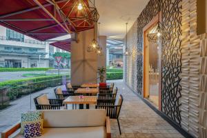 un restaurante con mesas, sillas y una pared en Residence Inn by Marriott San Jose Escazu, en San José
