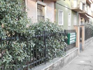 una recinzione di fronte a un edificio con un cespuglio di V & G House a Verona