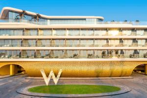 a large building with a gold facade with a circle in front at W Dubai - The Palm in Dubai