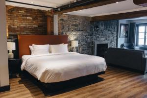 a bedroom with a large bed and a brick wall at Lofts du Vieux-Port by Gray Collection in Montréal