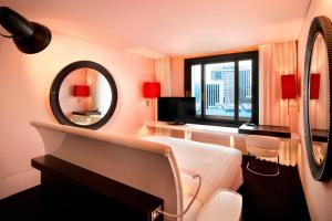 a hotel room with a bed and a mirror at THE PLAZA Seoul, Autograph Collection in Seoul