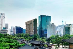 eine Skyline der Stadt mit hohen Gebäuden, Bäumen und Dächern in der Unterkunft THE PLAZA Seoul, Autograph Collection in Seoul