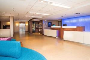 un vestíbulo de oficina con un sofá azul y un escritorio en Fairfield by Marriott Inn & Suites Raynham Middleborough/Plymouth, en Middleboro