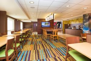 a dining room with tables and chairs and a tv at Fairfield by Marriott Inn & Suites Raynham Middleborough/Plymouth in Middleboro