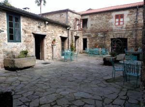 サンティアゴ・デ・コンポステーラにあるPR San Nicolásの石造りの建物内のパティオ(椅子、テーブル付)