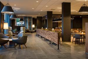 a lobby with tables and chairs and a restaurant at Courtyard by Marriott Prince George in Prince George