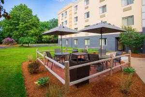 un patio con mesas y sombrillas frente a un edificio en Fairfield by Marriott Inn & Suites Raynham Middleborough/Plymouth, en Middleboro