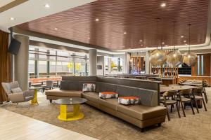 a lobby with a couch and tables and a bar at SpringHill Suites by Marriott Camp Hill in Camp Hill