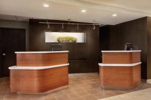 a lobby with brown walls and wooden reception desks at Courtyard by Marriott Topeka in Topeka