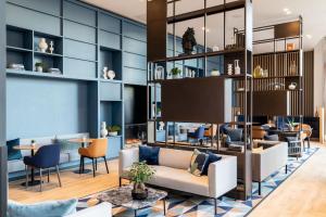 a lobby with a couch and chairs and tables at Courtyard by Marriott Glasgow SEC in Glasgow