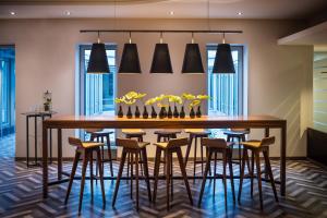 a dining room with a large wooden table and stools at Sheraton Duesseldorf Airport Hotel in Düsseldorf