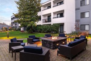 a patio with chairs and a fire pit in front of a building at Courtyard Seattle Southcenter in Tukwila