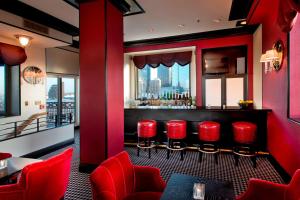 a bar with red chairs and a view of the city at Hotel ICON, Autograph Collection in Houston