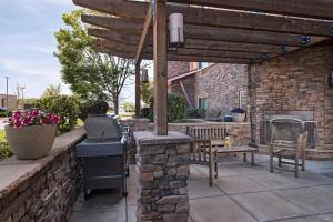 un patio con parrilla y pared de ladrillo en TownePlace Suites Fayetteville Cross Creek, en Fayetteville