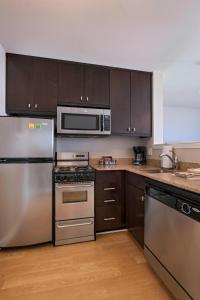 a kitchen with stainless steel appliances and wooden cabinets at TownePlace Suites Fayetteville Cross Creek in Fayetteville