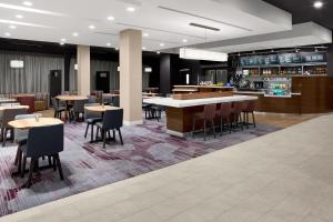 a restaurant with tables and chairs and a bar at Courtyard by Marriott Dallas Flower Mound in Flower Mound