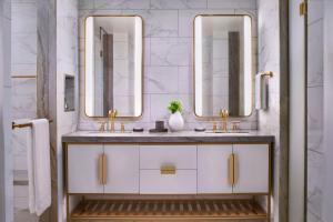 a bathroom with two sinks and two mirrors at The Ritz-Carlton, Naples in Naples