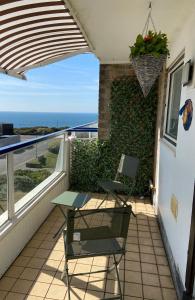 un tavolo e una sedia su un balcone con vista sull'oceano di Stunning 2 bed seaside apartment with Sea Views a Bournemouth