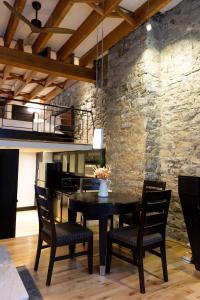 蒙特婁的住宿－Lofts du Vieux-Port by Gray Collection，一间设有桌椅和石墙的用餐室