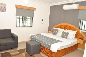 a bedroom with a bed and a chair at Ne-yo hotel & rv lodges in Asaba