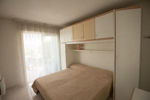 Habitación pequeña con cama y ventana en Quiet and cozy 1BR close to beach and all services, en Saint-Raphaël