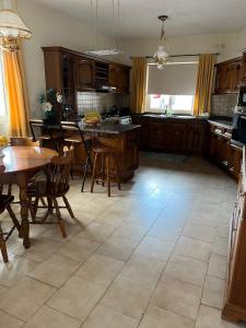 a kitchen with wooden cabinets and a table and chairs at Groundfloor Maisonette By The Seaside in St. Paul's Bay