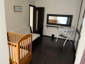 a hospital room with a crib and a tv at Groundfloor Maisonette By The Seaside in St Paul's Bay