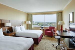 a hotel room with two beds and a desk at London Twickenham Stadium Hotel, a member of Radisson Individuals in Twickenham