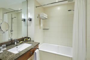 uma casa de banho com uma banheira, um lavatório e um chuveiro em London Twickenham Stadium Hotel, a member of Radisson Individuals em Twickenham