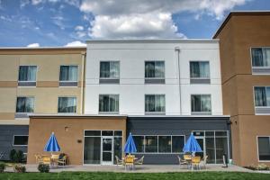 an exterior view of a hotel with tables and blue umbrellas at Fairfield Inn & Suites by Marriott Reading Wyomissing in Wyomissing
