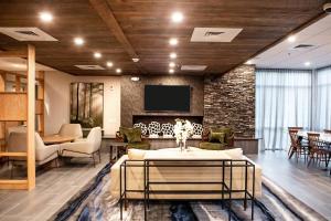 a living room with a couch and a tv at Fairfield Inn & Suites by Marriott Richmond Airport in Sandston