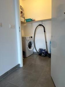 uma lavandaria com uma máquina de lavar roupa e uma máquina de lavar roupa em Appartement neuf proche Arcachon em La Teste-de-Buch