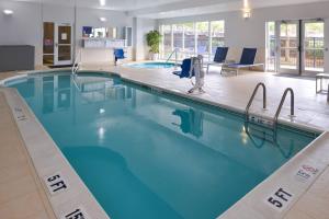 a large pool in a hotel room with blue water at SpringHill Suites Durham Chapel Hill in Durham