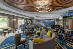 a lobby with couches and tables and a bar at SpringHill Suites Durham Chapel Hill in Durham