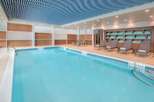 a swimming pool in a building with chairs and tables at Four Points by Sheraton Spartanburg in Spartanburg