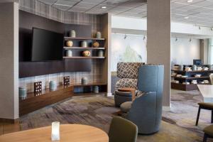 a lobby with a waiting area with a tv and chairs at Courtyard by Marriott Richmond Berkeley in Richmond